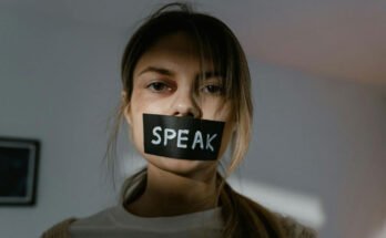 A women being silenced with tape over her face