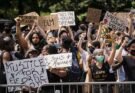 A group of protestors holding up BLM and “Justice For George Floyd” signs